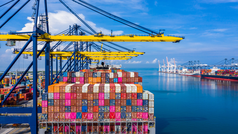 Container cargo ship at industrial port in import export business logistic and transportation of international by container cargo ship in the open sea, Aerial view.